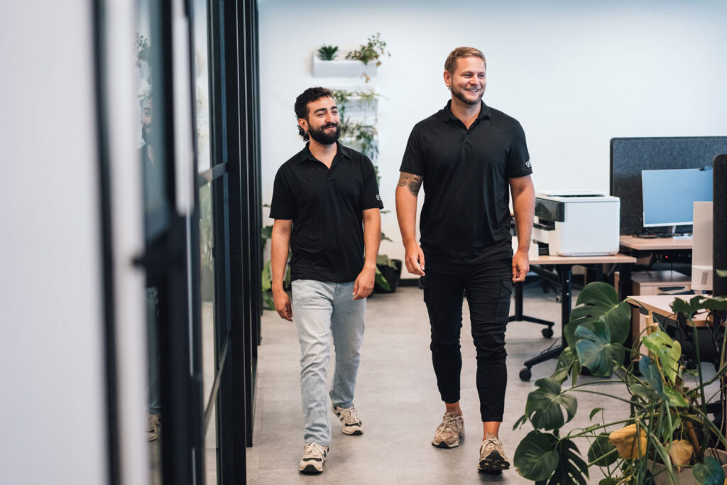 Two people walking in an office